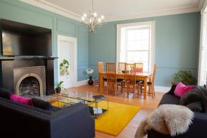 a living room with a fireplace and a dining room at Starbright Cottage in Peebles