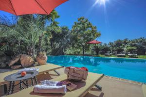 a resort with a pool with tables and an umbrella at Pozzo Antico in Morlupo