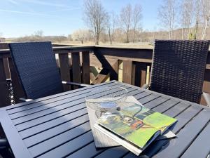 a table with a book on it on a deck at Haus an der Düne Whg 10 in Lobbe