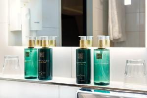 a group of four green bottles sitting on a counter at Hotel Die Port van Cleve in Amsterdam
