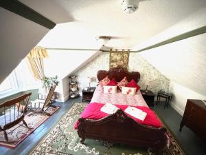 a bedroom with a large red bed in a attic at Rosebank House Bed & Breakfast in Strathyre