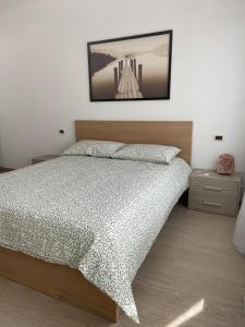 a bedroom with a bed and a picture on the wall at Amalia-Levico Terme Apartment in Levico Terme