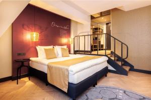 a bedroom with a large bed and a staircase at Hotel Die Port van Cleve in Amsterdam