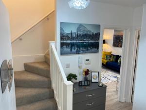 a hallway with a staircase with a picture on the wall at Charming 2- Bedroom Apartment in Watford