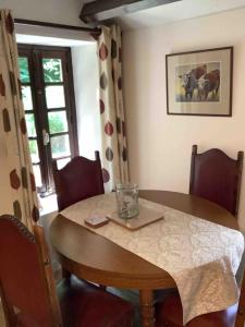 einen Esstisch mit einem Glas darüber in der Unterkunft Woodland Cottage in Faux-la-Montagne