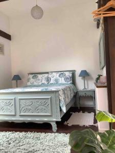 1 Schlafzimmer mit einem weißen Bett und 2 Tischen in der Unterkunft Woodland Cottage in Faux-la-Montagne + 12 Fotos