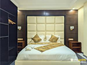 a bedroom with a large bed with a large headboard at Chic studio with parking near the airport in Douala +12 photos