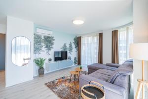 a living room with a couch and a tv at MyFlat Wave Beach Apartments in Siófok