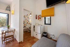 a room with a kitchen with a table and a refrigerator at Amado Properties in Carrapateira