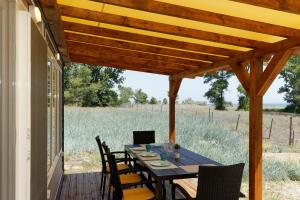 a dining table on a porch with a view of a field at KRAPEC Beach in Krapets