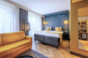 a hotel room with a bed and a couch at Hotel Die Port van Cleve in Amsterdam