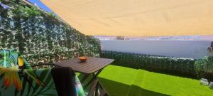 a small table on a balcony with a view of the water at Apartamento Arena y Sal in Barbate +11 photos