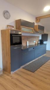 a kitchen with blue cabinets and a clock on the wall at Heu und Himmel Loft in Innsbruck +34 photos