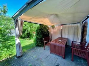 a tent with a wooden table and benches on a patio at Haus in Ossendorf Köln in Cologne