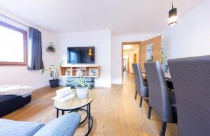 a living room with a couch and a table and chairs at Farm apartment in Stelvio National Park in Prato allo Stelvio