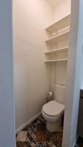 ein kleines Bad mit WC und Regalen in der Unterkunft Studio Machy - Centre-Ville et Parking Gratuit in Bourbourg + 49 Fotos