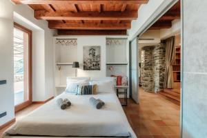a bedroom with a large white bed with two pillows at Crotto Polirolo by "The House Of Travelers" in Cernobbio