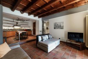 a living room with a couch and a tv and a kitchen at Crotto Polirolo by "The House Of Travelers" in Cernobbio