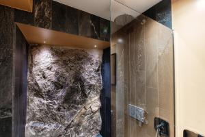 a bathroom with a shower with a stone wall at Crotto Polirolo by "The House Of Travelers" in Cernobbio +76 photos