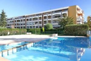 a building with a swimming pool in front of a building at LX112 Balcon, jardin, piscine, résidence privée in Mandelieu-la-Napoule