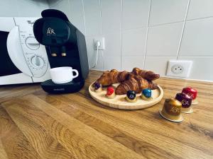 a plate of croissants on a counter next to a coffee maker at LX112 Balcon, jardin, piscine, résidence privée in Mandelieu-la-Napoule