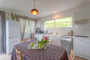 a kitchen with a table with a purple table cloth at Maison de vacances Camille in Artigues