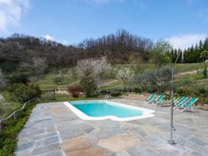 a swimming pool with two chairs in a yard at Agriturismo La Rovere - Casale De Rovere in Cossano Belbo
