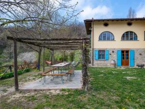a patio with a table and chairs in front of a house at Agriturismo La Rovere - Casale De Rovere in Cossano Belbo