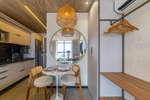a dining room with a table and chairs and a mirror at New Time 715 - Luxo à beira-mar da Pajuçara in Maceió