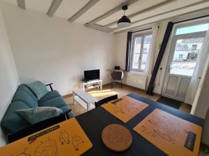 a living room with a couch and a table at La Petite Maison Tourangelle in Cheillé