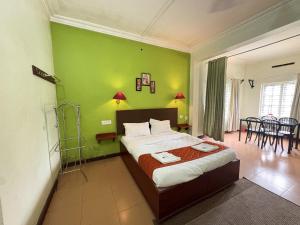 una camera da letto con un letto e una parete verde di Hotel SilverLine Regency Munnar a Munnar