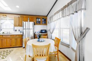 a kitchen with a table with chairs and a refrigerator at Key West Villa Heated Priv Pool Spa 7beds, Arcade in Wildwood