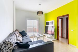a living room with a couch and a tv at Apartamento Aire Mediterráneo R&R in Aguadulce +32 photos