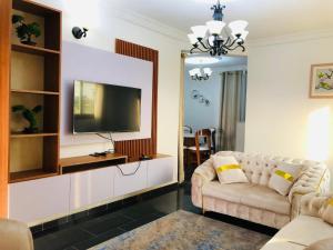 a living room with a couch and a flat screen tv at BSA Douala in Douala