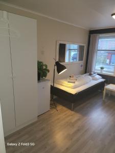 a bedroom with a bed and a window at Koselig rom i sentrum Gratis Wifi og Parkering Rom 3 1 etg in Narvik