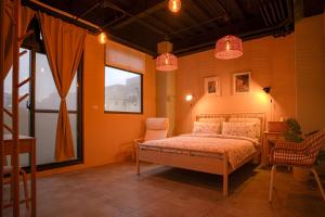 una camera da letto con un letto, due sedie e una finestra di 小島月光民宿 Moonlit Isle a Green Island