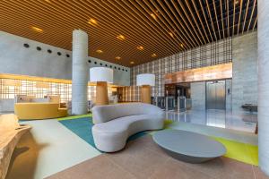 a lobby with a couch and a table in a building at New Time 715 - Luxo à beira-mar da Pajuçara in Maceió