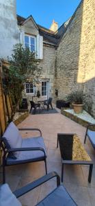a patio with chairs and a table and a building at Belle maison de ville in Alençon