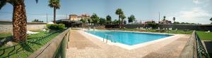a swimming pool in front of a house at Camping Palacio de Garaña in Garaña