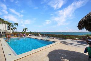 une piscine avec l'océan en arrière-plan dans l'établissement Charming waterfront island condo - minutes to Englewood Beach - Mystic Sea, à Englewood