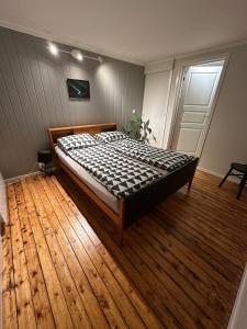 Ce lit se trouve dans un dortoir doté de parquet. dans l'établissement Cozy 2-bedroom apartment in the city centre, à Tromsø