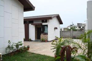 a white house with a courtyard at Toosonj Guest House in Guwahati