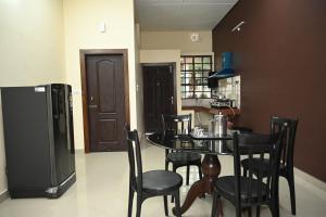 a kitchen with a table and chairs and a refrigerator at Toosonj Guest House in Guwahati