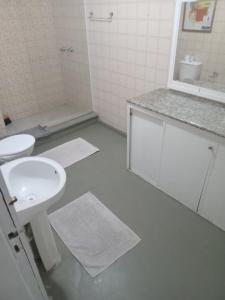 ein weißes Badezimmer mit Waschbecken und Toilette in der Unterkunft Quarto a 150m da Praia do Farol da Barra II in Salvador