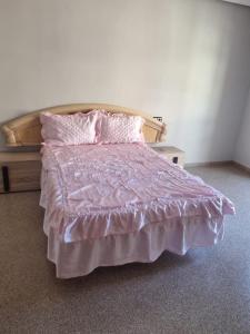a bedroom with a bed with a pink comforter at Piso in Castalla +6 photos