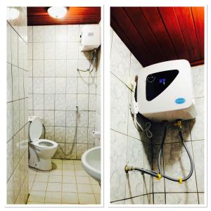a bathroom with a toilet and a soap dispenser on the wall at BSA Douala in Douala +11 photos