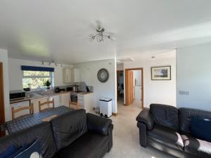 a living room with a couch and a kitchen at Sunnyview Annexe in Saint Briavels