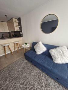 a blue couch in a living room with a mirror at Espectacular vista y ubicación in Santiago