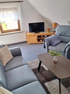a living room with two couches and a tv at Kapitänskoje in Breege