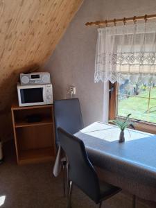 a dining room with a table with a microwave and a window at Kapitänskoje in Breege